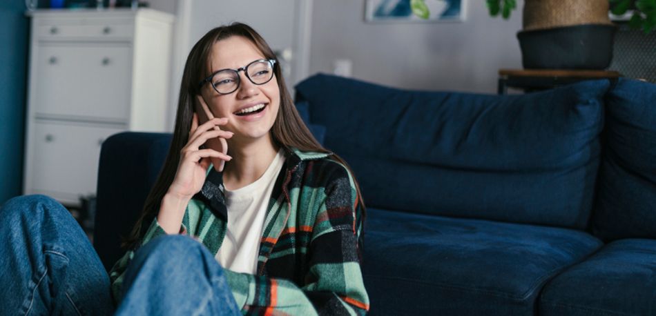 Jovem a sorrir enquanto fala ao telemóvel